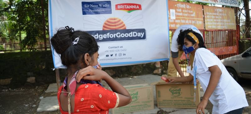Girl recieving GoodDay cookie from volunteer