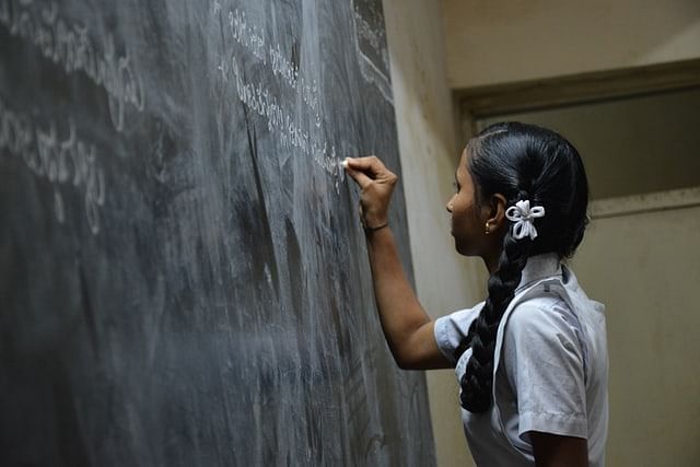 Girl writing on a black board