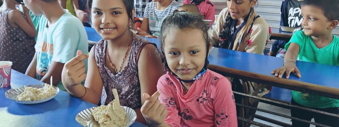 Two girls having nutritious food under Malnutrition Project by Pledge Foundation