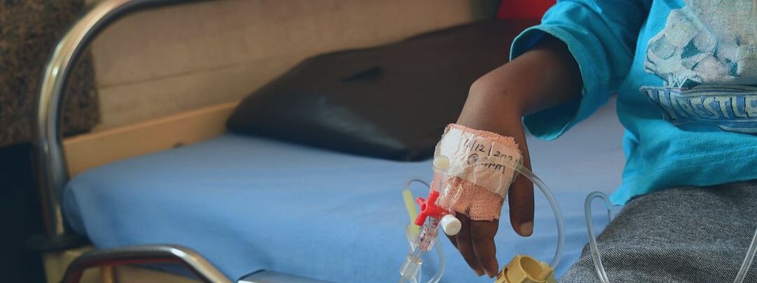 Child with saline solution on hand